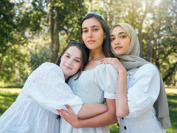 Group of women hug, show diversity, support and solidarity together, against forrest or garden background. Multicultural friends stand in unity, in outdoor portrait with trees or woods in backdrop. - Photo, Image