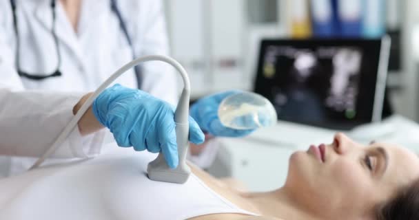 Profesionální gynekolog provádějící vyšetření prsu pacientky se silikonovými implantáty pomocí ultrazvukového skeneru. Zdravotnictví a kontrola povědomí o rakovině na klinice - Záběry, video