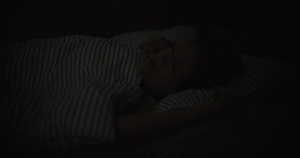 Jonge vrouw in bed opende haar ogen slapeloze schijnende helder blauw licht. Nachtmerries en dromen - Video