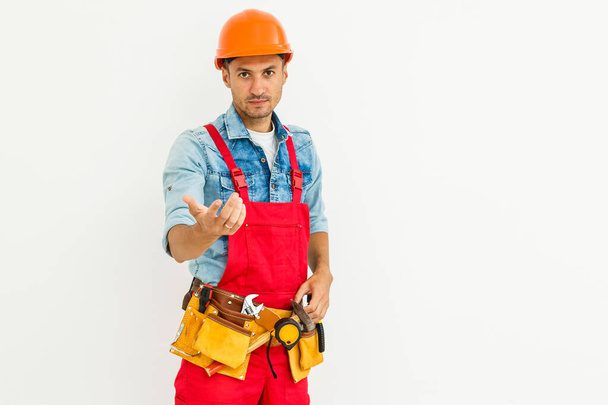 Retrato de jovem trabalhador alegre usando chapéu duro sobre fundo branco. - Foto, Imagem