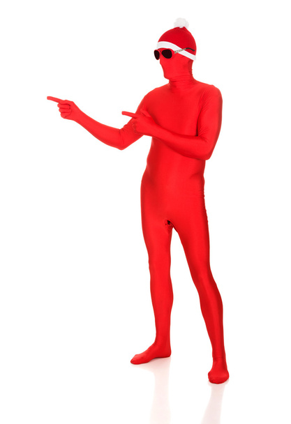 Full length santa man in latex clothing pointing - Foto, Imagen