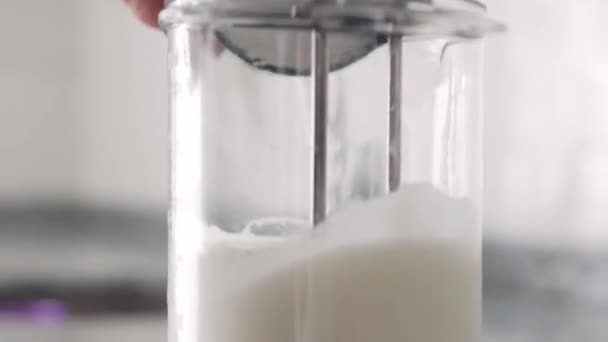 Biczowanie syropu cukrowego w śmietanie w szklanym pojemniku i dodawanie cukru w proszku. Środek strzału - Materiał filmowy, wideo