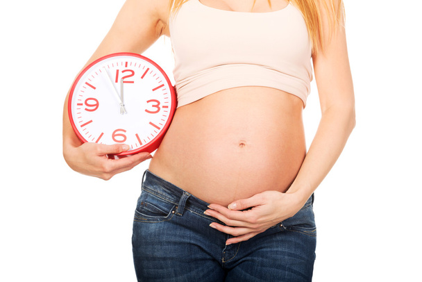 Pregnant woman with a big clock - Zdjęcie, obraz
