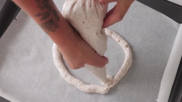 Una mujer panadero pone la crema en el papel de hornear en forma de círculo. Mid shot - Metraje, vídeo