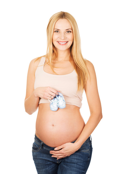 Mujer embarazada con pequeños zapatos azules
 - Foto, imagen