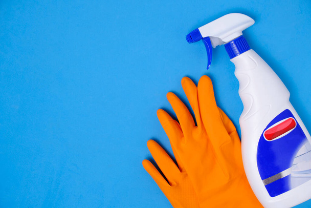 Sprayer for cleaning windows and plumbing and protective rubber gloves blue background - Foto, afbeelding