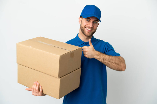 Delivery man over isolated white background giving a thumbs up gesture - Фото, изображение