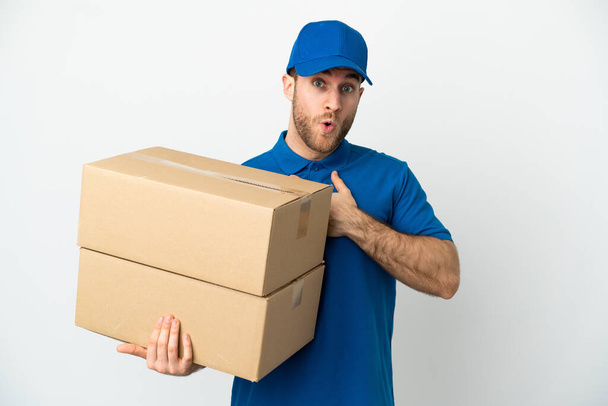 Delivery man over isolated white background surprised and shocked while looking right - Foto, afbeelding