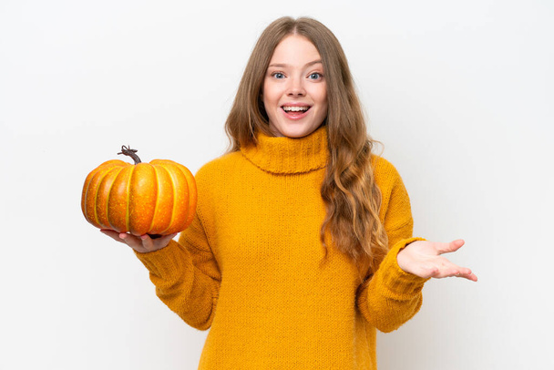 Young pretty woman holding a pumpkin isolated on white background with shocked facial expression - Photo, Image