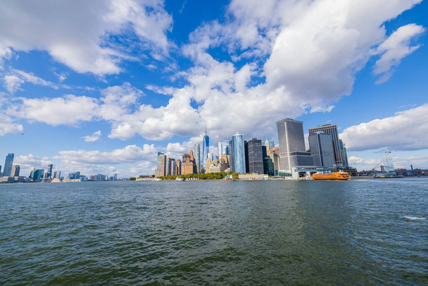 白い雲と青空の下でハドソン川の両側にマンハッタンの高層ビルの豪華な景色。ニューヨーク,アメリカ. - 写真・画像