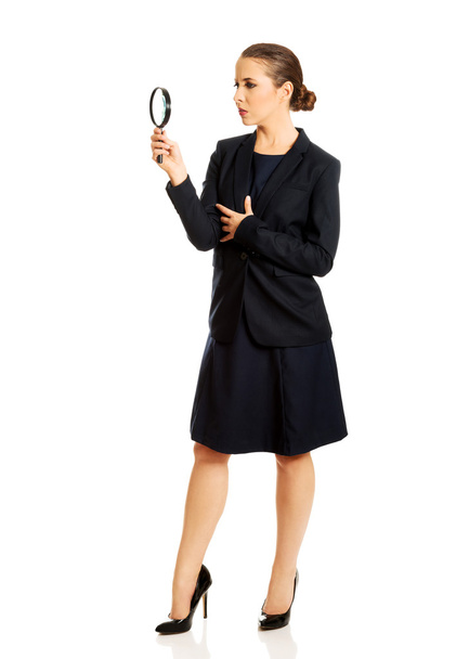 Smiling businesswoman with magnifying glass - Valokuva, kuva