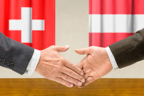 Representantes de Suiza y Austria se dan la mano
 - Foto, Imagen