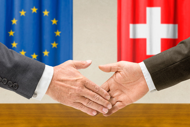 Eu とスイス連邦共和国の代表者が握手します。 - 写真・画像