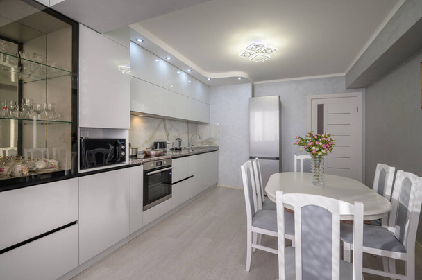 Interior of well designed modern trendy white kitchen, corner view - Photo, Image