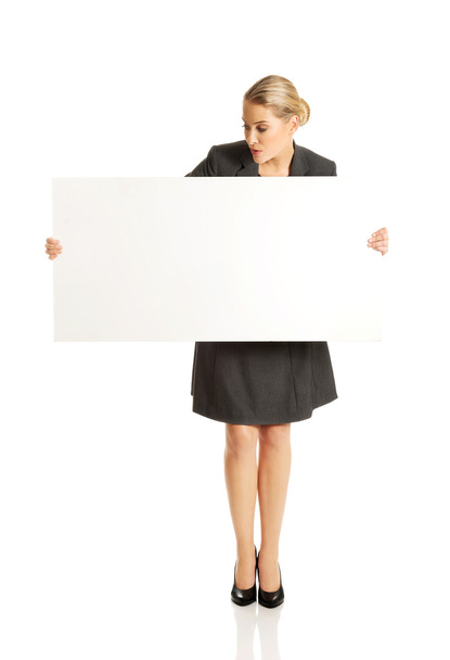 Businesswoman holding empty billboard - Valokuva, kuva