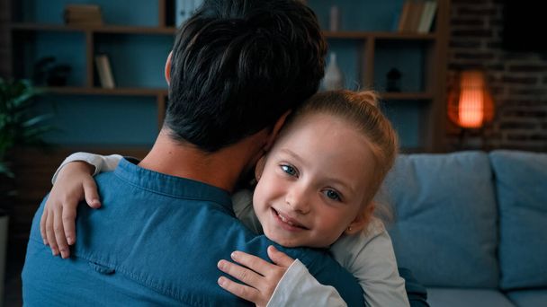 Loving cute daughter hugging adorable daddy happy young caucasian family single father embracing little child girl at home on Fathers day parental love tenderness emotions relaxing together on sofa - Φωτογραφία, εικόνα