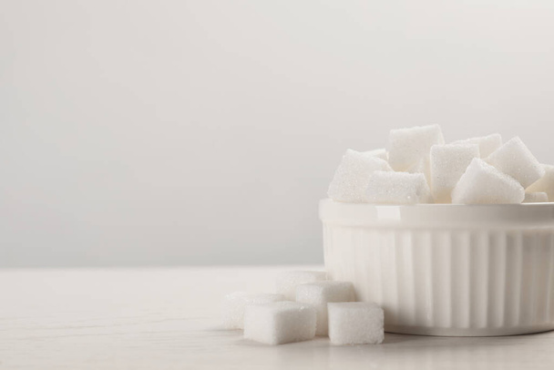 Bowl with sugar cubes served on white table. Space for text - Fotografie, Obrázek