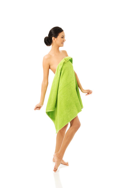 Full length woman standing wrapped in towel - Fotó, kép