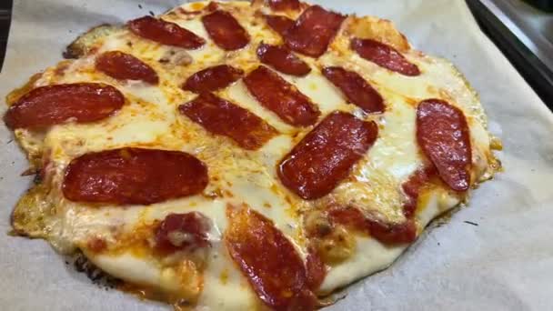 Gorąca pizza pepperoni domowej roboty na blasze do pieczenia, zbliżenie. Wysokiej jakości materiał 4k - Materiał filmowy, wideo