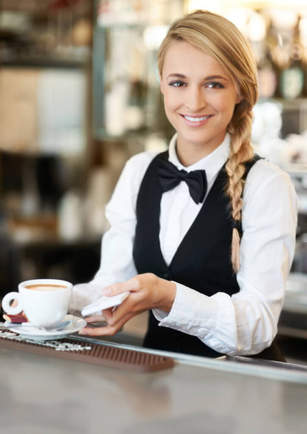 Vain parasta kahvia sinulle. Nuori kaunis tarjoilija valmistautuu tarjoilemaan herkullista kahvia asiakkaalle - Valokuva, kuva