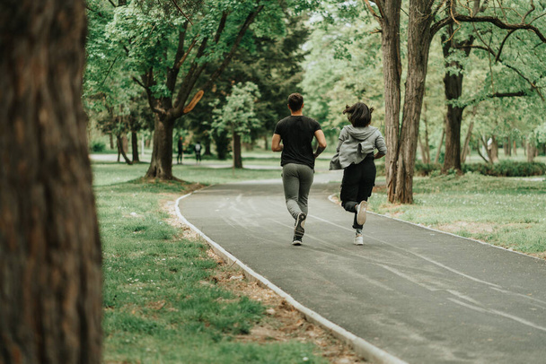Para biegająca po ścieżce w parku - Zdjęcie, obraz