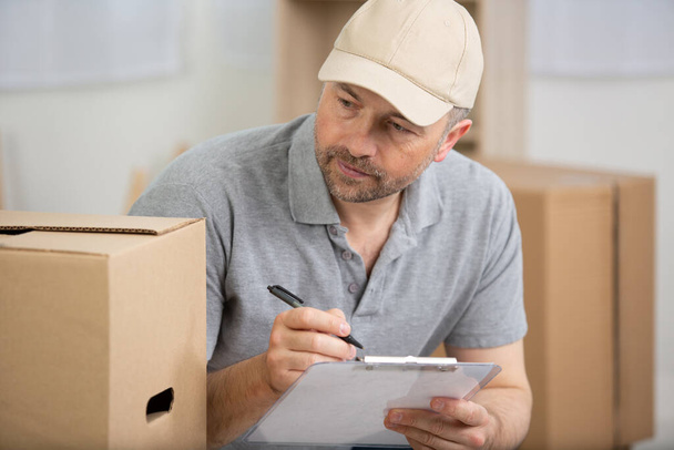 deliveryman with boxes and clipboard - Photo, Image