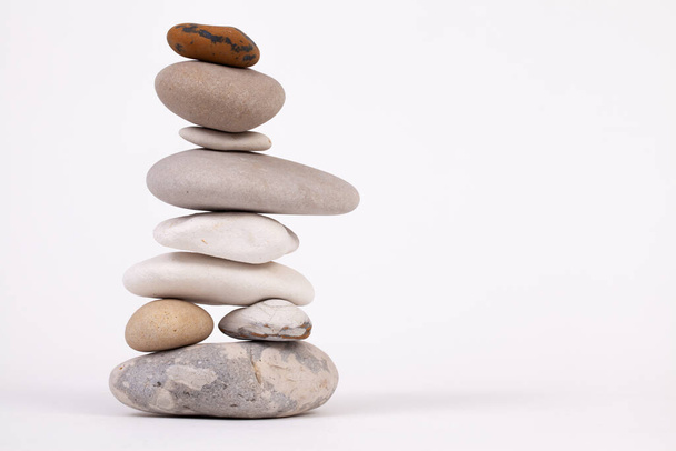 Beech pebbles column isolated on a white studio background. Zen relaxation concept - Photo, Image