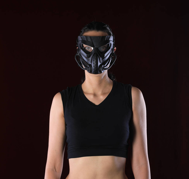 girl in an apocalypse mask on a black background - Foto, imagen