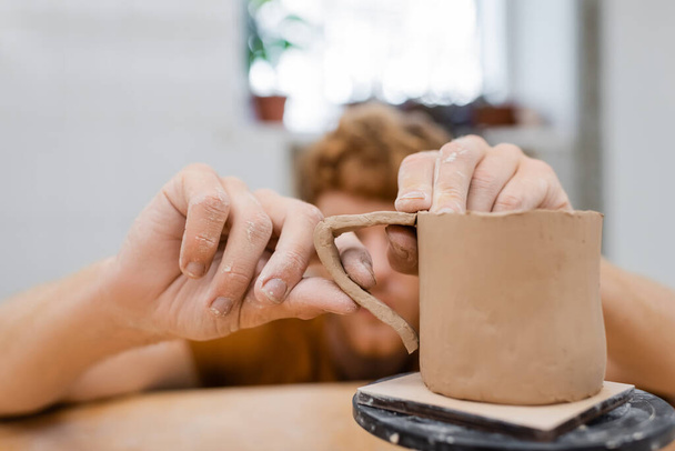 Sfocato artigiano fare tazza di argilla in studio di ceramica  - Foto, immagini