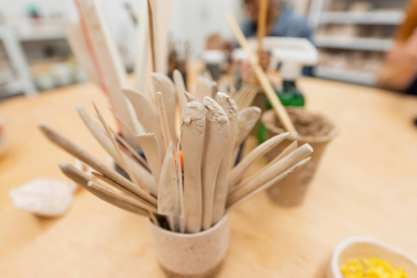 Outils céramiques sur table dans un atelier de poterie floue  - Photo, image