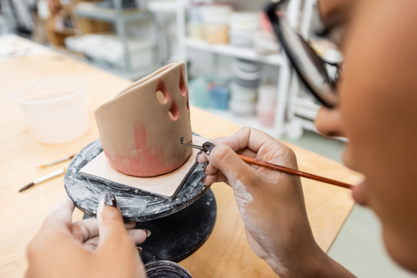 Pittura sfocata di donna afro-americana su scultura in ceramica in laboratorio  - Foto, immagini