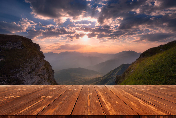 Estate bellissimo sfondo con alba sulle montagne e tavolo in legno vuoto nella natura all'aperto. Paesaggio modello naturale. - Foto, immagini