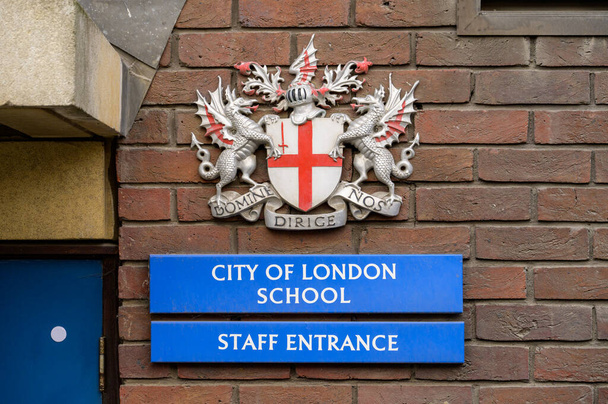 ロンドン- 2022年5月21日：ロンドン市武器コート、レンガの壁に学校とスタッフの入り口の標識 - 写真・画像