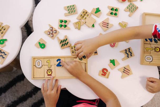 Top view of kids put together educational puzzles. - 写真・画像