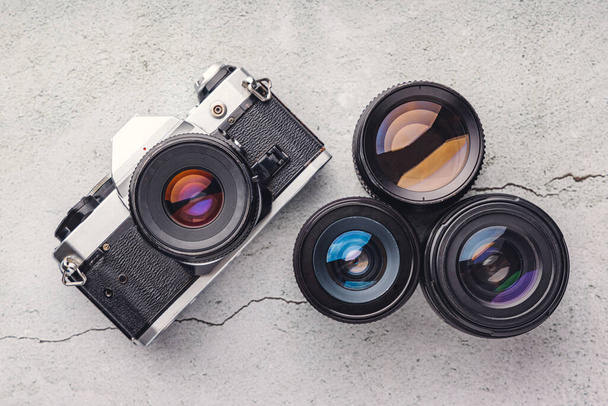 Starý vintage fotoaparát, objektiv a film kamera film film film roll close up na kamenném pozadí - Fotografie, Obrázek