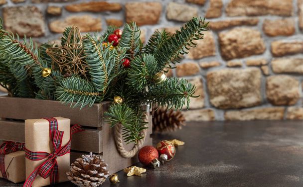 Zabalené dárkové krabice v blízkosti vánoční výzdoby, borové šišky a zelené jedle větve zavřít na dřevěném pozadí s kopírovacím prostorem, zblízka. Vánoční nebo novoroční prázdninová atmosféra - Fotografie, Obrázek