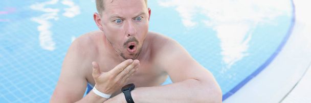 Um homem chocado na piscina olha para um portátil, de perto. Colapso financeiro, notícias. Freelancer em férias - Foto, Imagem