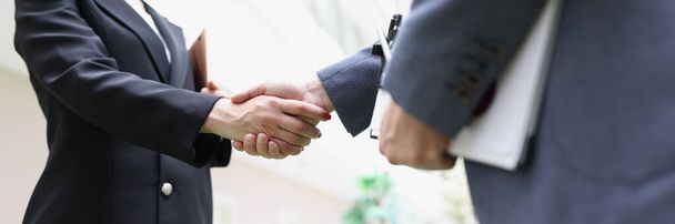 Businessmen in suits shaking hands in the lobby of the building, blurry. Business decisions concept, support gender equality tend - Photo, Image