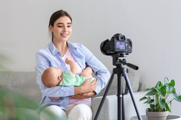 Junge Frau mit Baby nimmt Videokurs zu Hause auf - Foto, Bild