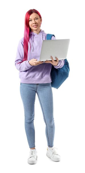 Beyaz arka planda dizüstü bilgisayarı tutan parlak, sıra dışı saçlı genç bir kız öğrenci. - Fotoğraf, Görsel