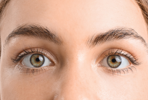 Mujer joven con hermosos ojos de avellana sobre fondo blanco, primer plano - Foto, Imagen