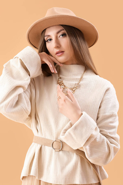 Beautiful fashionable young woman on beige background - Foto, Imagem