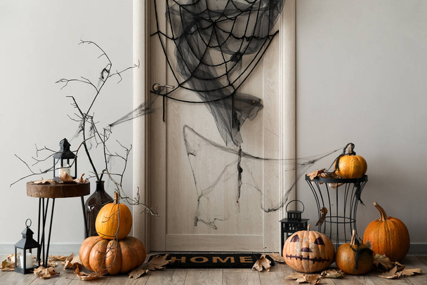Интерьер светлого зала украшен на Хэллоуин дверью и столами - Фото, изображение
