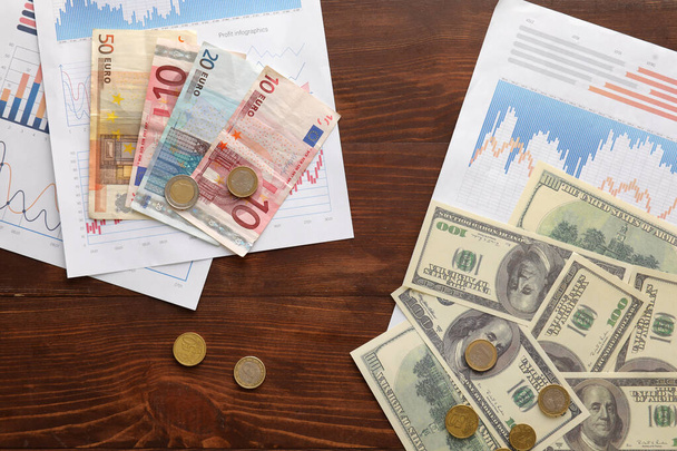 Деньги и диаграммы на темном деревянном фоне. Концепция обменного курса - Фото, изображение