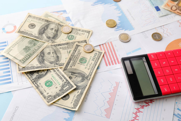 Banknoty dolarowe z monetami, kalkulatorem i diagramami na niebieskim tle. Koncepcja kursu walutowego - Zdjęcie, obraz
