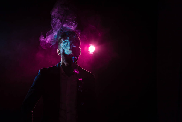 Photo of man smoking on pink background. Concept of smoking. - Фото, изображение