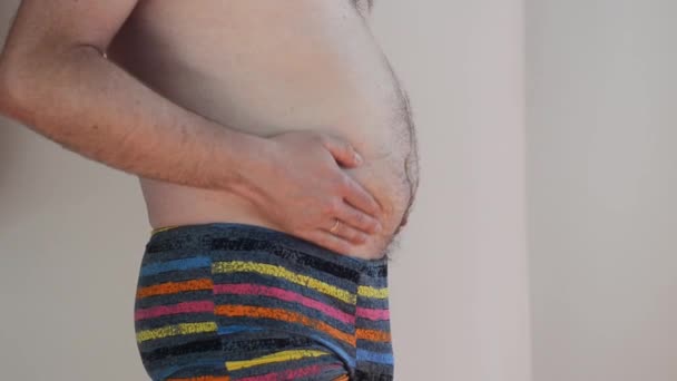 Mann in Unterwäsche mit dickem Bauch, übergewichtiger männlicher Körper isoliert auf weißem Hintergrund. Abnehmen. Konzept der Chirurgie, subkutane Fettabbau. Körper positiv. Bauchmassage, Bauchdeckenstraffung - Filmmaterial, Video
