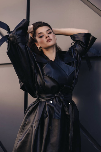 fashion outdoor photo of beautiful woman with dark hair in elegant leather coat - Valokuva, kuva
