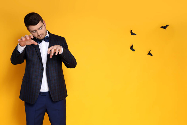Concept of Halloween, young man on yellow background - 写真・画像