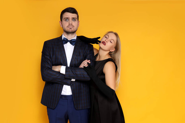 Concept of Halloween, young man and woman on yellow background - Foto, Imagen